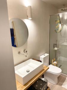 a bathroom with a white sink and a toilet at Architect designed house with pool and private beach in Eretria