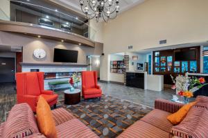 a lobby with a couch and two chairs and a tv at Best Western Plus Chateau Fort St. John in Fort Saint John