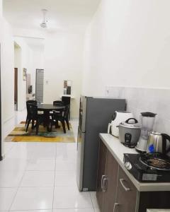 スンガイ・ブサールにあるHomestay Dorani Sungai Besarのキッチン(コンロ、テーブル、椅子付) +12枚の写真