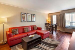 a living room with a red couch and a table at Quality Inn Airport West in Mississauga