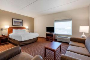 マディソンにあるClarion Suites at the Alliant Energy Centerのベッド1台、薄型テレビが備わるホテルルームです。