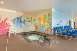 een zwembad in een kamer met een muurschildering van vis bij Clarion Suites at the Alliant Energy Center in Madison