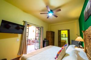 - une chambre avec un lit et un ventilateur de plafond dans l'établissement La Casona Chapala, à Chapala