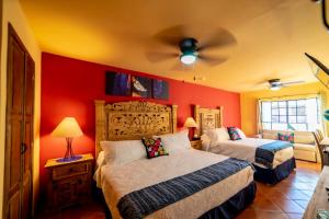 - une chambre avec 2 lits et un ventilateur de plafond dans l'établissement La Casona Chapala, à Chapala