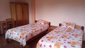 1 dormitorio con 2 camas, mesa y armario en Hospedaje Franco-Peruano El Tambito, en Sauce