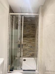 een douche met een glazen deur in de badkamer bij GRAND T2 GARE AMIENS TOUT CONFORT 2PERS WIFI in Amiens