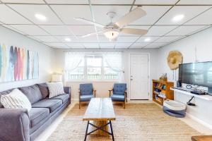Unit 32, Island Retreat Resort في ميناء أرانساس: غرفة معيشة مع أريكة وتلفزيون