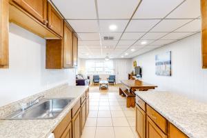 a kitchen with a sink and a living room at Unit 32, Island Retreat Resort in Port Aransas