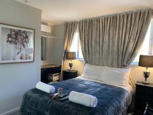 a bedroom with a bed with blue sheets and white pillows at Freshwater BnB in Hervey Bay