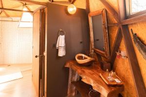 bagno con lavandino in legno e specchio di La Colina Glamping a La Vega