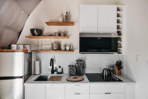 a kitchen with white cabinets and a sink and a refrigerator at FlowEdge Riverside Getaway in Meaghers Grant