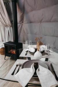 a dining room table with a plate and a fireplace at FlowEdge Riverside Getaway in Meaghers Grant