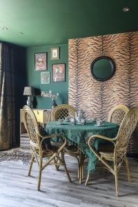 une salle à manger avec une table et des chaises vertes dans l'établissement The Emerald Suite by Margate Suites, à Margate