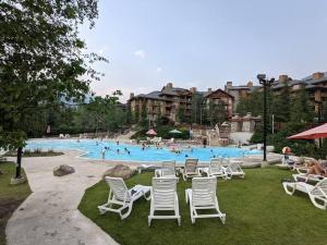 a large pool with white chairs and people in it at The Upper Tip, Elevate your vacation, with Hot Pool and Hot Tub in Panorama