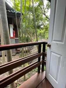 an open door to a porch with a fence at Baantip Suantong in Amphawa
