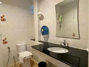 La salle de bains est pourvue d'un lavabo, de toilettes et d'un miroir. dans l'établissement Baantip Suantong, à Amphawa