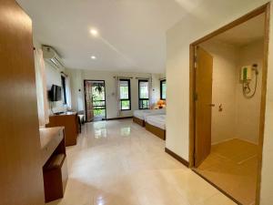 a large room with a bed and a bathroom at Baantip Suantong in Amphawa