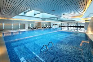 a large swimming pool in a large building at Langham Place Guangzhou - Walking distance to Canton Fair in Guangzhou