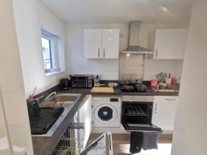 a kitchen with a washing machine and a sink at Large 65 Inch TV Full Kitchen Long-Stay Ready in Liverpool
