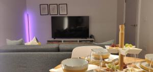 a living room with a couch and a table with food at Large 65 Inch TV Full Kitchen Long-Stay Ready in Liverpool
