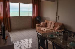 uma sala de estar com um sofá e uma mesa em Lindo Flat Mar Azul em São José da Coroa Grande, Pernambuco em São José da Coroa Grande