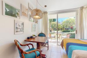 a bedroom with a table and chairs and a bed at Islander on the Beach 171 in Kapaa