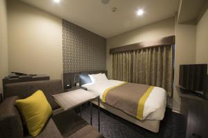 um quarto de hotel com uma cama e uma televisão em Almont Inn Tokyo Nihonbashi em Tóquio