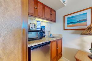 a small kitchen with a sink and a microwave at Islander on the Beach 354 in Kapaa