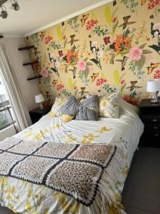 een slaapkamer met een bed met bloemenbehang bij Reñaca Departamento 2D 2B in Viña del Mar