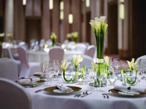 a table with white tables with glasses and flowers at Langham Place Guangzhou - Walking distance to Canton Fair in Guangzhou