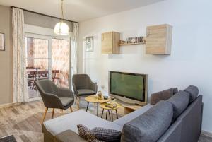 ein Wohnzimmer mit einem Sofa und einem TV in der Unterkunft Apartments and rooms with parking space Biograd na Moru, Biograd - 6219 in Biograd na Moru