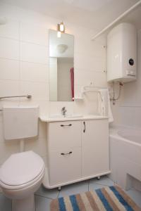 Baño blanco con aseo y lavamanos en Apartments by the sea Merag, Cres - 7877, en Cres