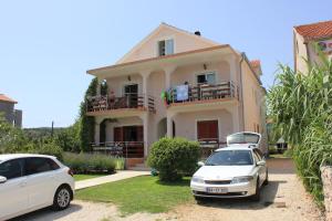 two cars parked in front of a house at Apartments by the sea Kraj, Pasman - 8247 in Tkon