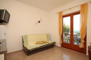 a room with a bed and a door with a balcony at Apartments by the sea Kraj, Pasman - 8247 in Tkon