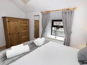 a bedroom with a white bed and a window at Bridgeway House in Blaenau-Ffestiniog