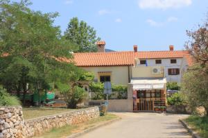 a house with a gate and a stone wall at Studio Cres 7984a in Cres
