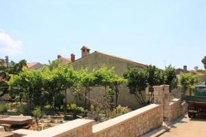 a garden in front of a house with a retaining wall at Studio Cres 7984a in Cres