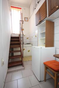 a kitchen with a ladder and a white refrigerator at Studio Cres 7984a in Cres