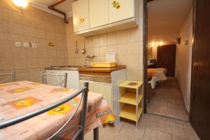 a small kitchen with two tables and a counter at Apartments with a parking space Cres - 7984 in Cres