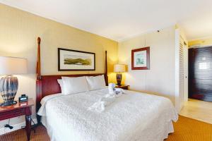 a bedroom with a white teddy bear sitting on a bed at Kauai Beach Resort #1317 in Lihue