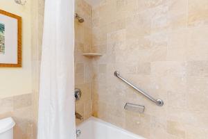 a bathroom with a shower with a tub and a toilet at Kauai Beach Resort #1317 in Lihue
