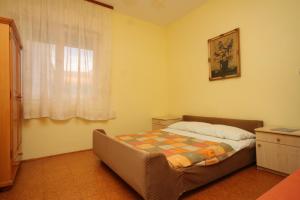 um pequeno quarto com uma cama e uma janela em Apartments and rooms with parking space Bozava, Dugi otok - 8100 em Božava