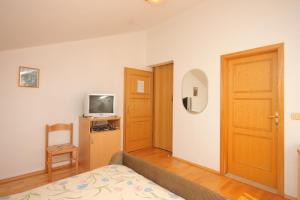 a room with a bed and a television and a door at Double Room Bozava 8100a in Božava
