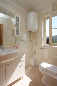 a white bathroom with a toilet and a sink at Double Room Bozava 8100a in Božava