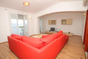 - un canapé rouge dans une pièce avec un salon dans l'établissement Apartment Preko 8384c, à Preko