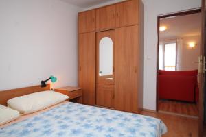 - une chambre avec un lit, une armoire et un miroir dans l'établissement Apartment Preko 8384c, à Preko