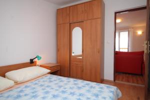 sypialnia z łóżkiem, szafką i lustrem w obiekcie Apartment Preko 8384c w mieście Preko
