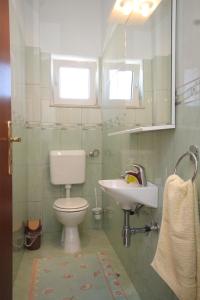 a bathroom with a toilet and a sink at Apartment Preko 8384c in Preko