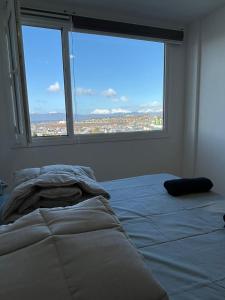 Cama en habitación con 2 ventanas grandes en Ledacy La vitta Bella en Ushuaia