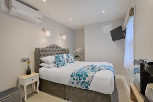 um quarto com uma cama grande e almofadas azuis em Number 31 Boutique Townhouse em Galway